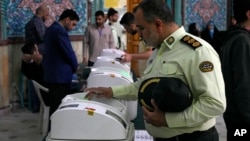 An Iranian police colonel votes in Iranian parliamentary elections that were reportedly marred by low turnout.