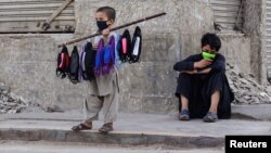 A young boy sells face masks on a stick in Karachi. 