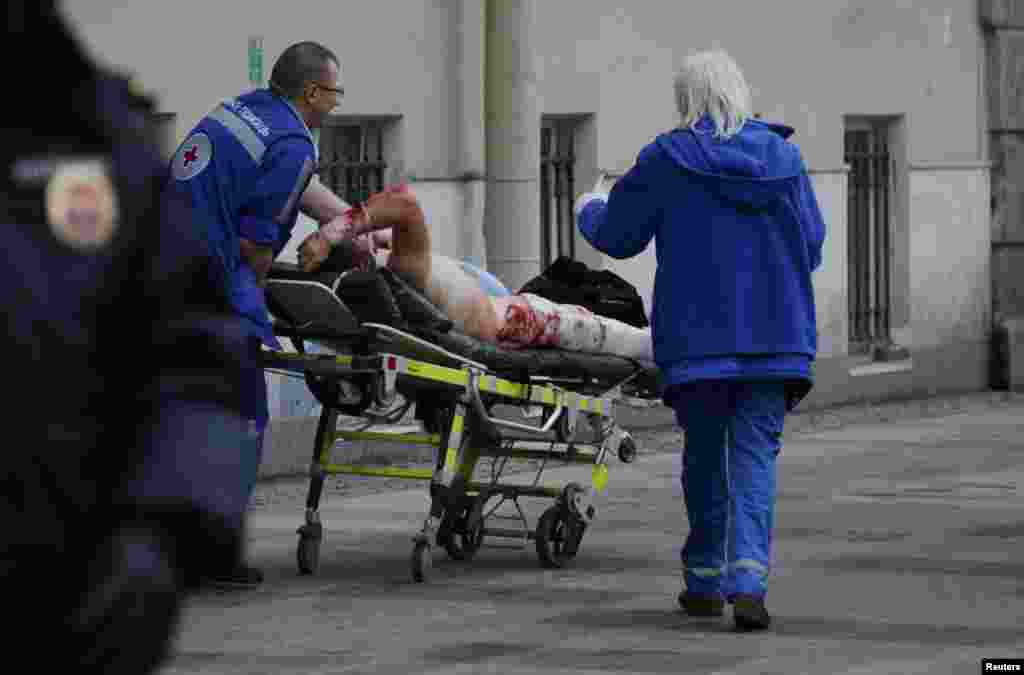 Emergency-services personnel tend to an injured person outside the Sennaya Ploshchad subway station.