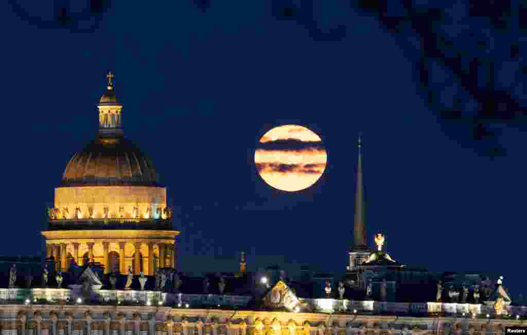The full moon sets behind Saint Isaac's Cathedral in central Saint Petersburg, Russia.