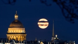 <p>The full moon sets behind Saint Isaac's Cathedral in central Saint Petersburg, Russia. 