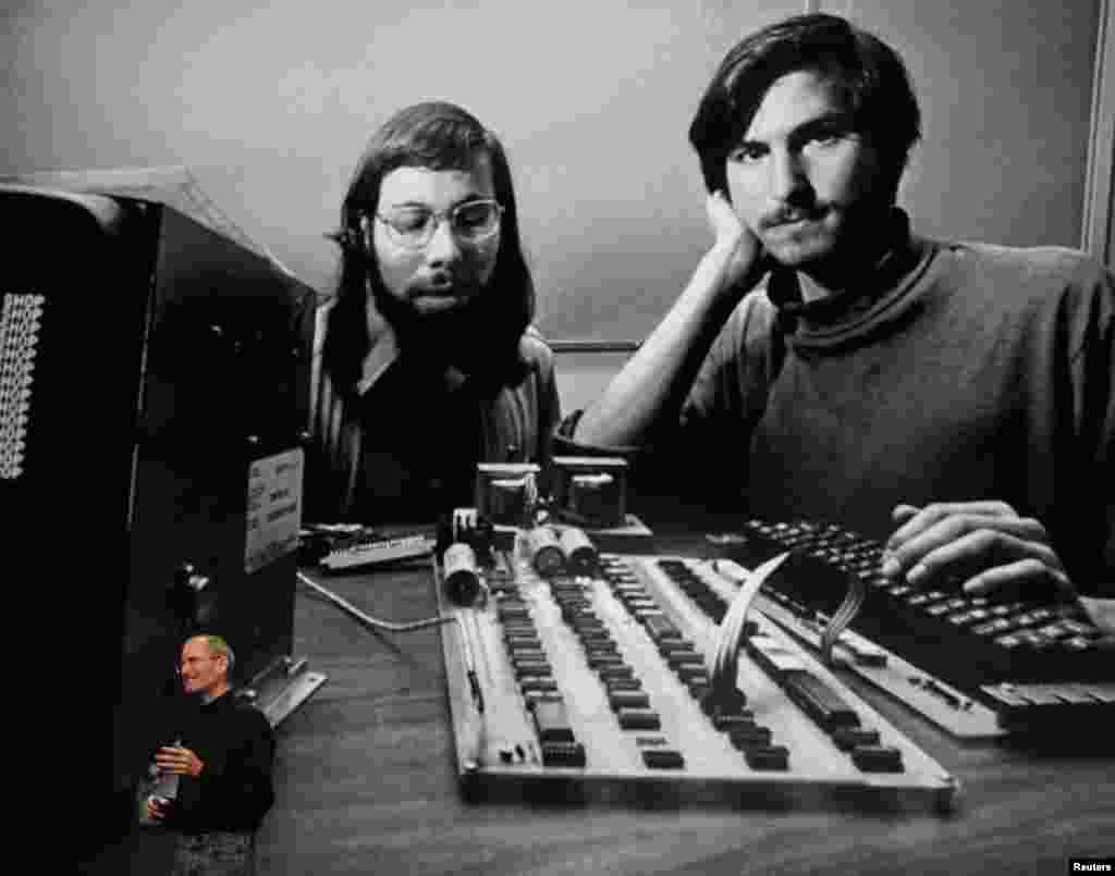 Apple Chief Executive Officer Steve Jobs stands beneath a photograph of himself and Apple co-founder Steve Wozniak from the early days of Apple during the launch of Apple's new iPad tablet computer in San Francisco, California on January 27, 2010.