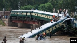 Security officials rescue passengers after train cars fell into a canal following the partial collapse of a bridge in Wazirabad in Punjab Province on July 2.