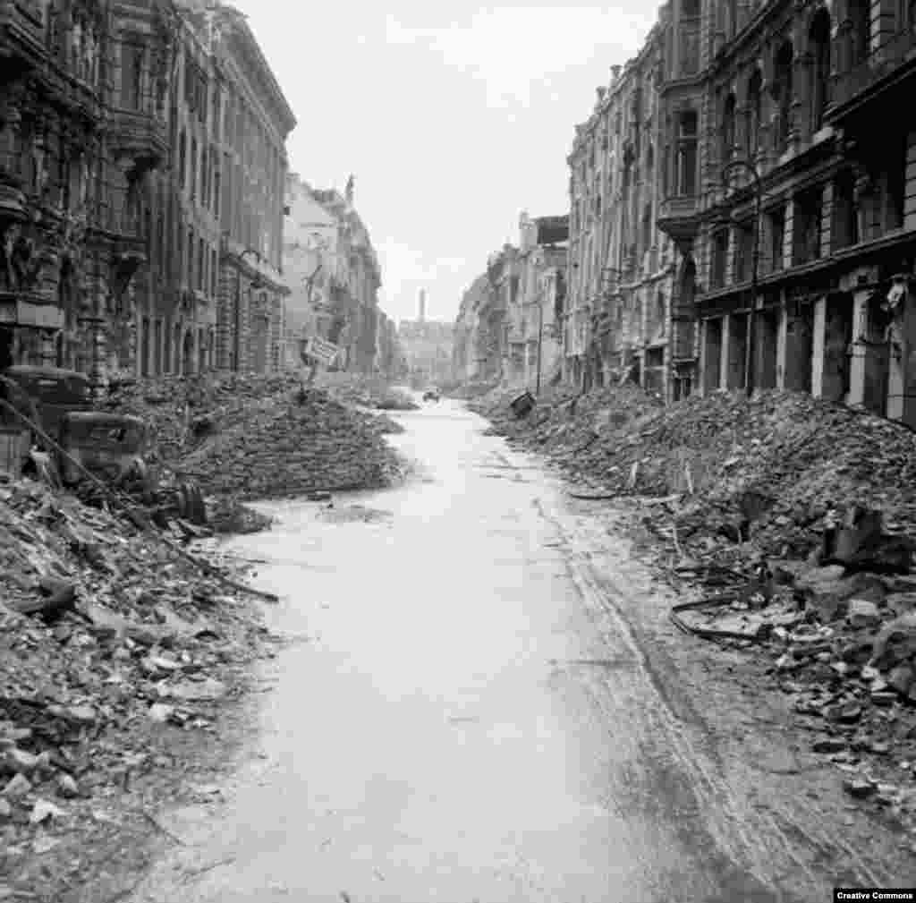 A car drives down a gutted Berlin street. &nbsp; Much of the damage was from British, American, and French bombing raids that killed tens of thousands of civilians.&nbsp; &nbsp;