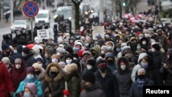 People, including pensioners, parade through the streets during a rally to protest against police violence in Minsk on November 30.