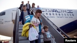 Пассажиры спускаются по трапу самолета в аэропорту в Тель-Авиве. 