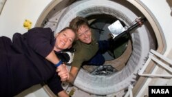 Peggy Whitson (sağda) BKS-da onu əvəzləyəcək astronavt Pam Melroy-u salamlayır. 2007