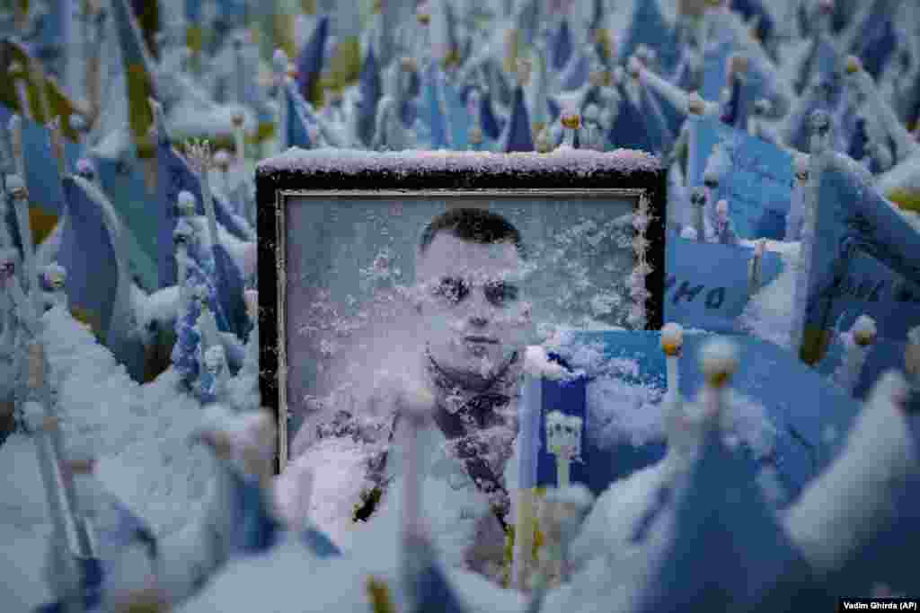 Snowflakes cover the photograph of a fallen Ukrainian soldier in Kyiv.