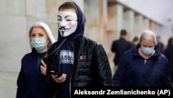 People wearing face masks of various sorts to help curb the spread of the coronavirus walk inside the Moscow subway on June 10.