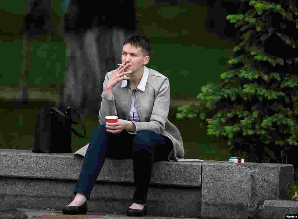 Ukrainian military aviator and parliamentary deputy Nadia Savchenko smokes and drinks a coffee near the parliament building before her first session in parliament on May 31 after being freed by Russia as part of a prisoner swap. (Reuters/Gleb Garanich)