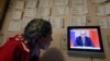 A woman watches a news program showing Russian President Vladimir Putin making a statement about the Syria situation in St. Petersburg on September 30.