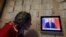 A woman watches a news program showing Russian President Vladimir Putin making a statement about the Syria situation in St. Petersburg on September 30.