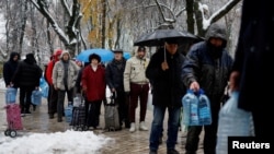 Stanovnici Kijeva čekaju u redu za vodu nakon što je kritična civilna infrastruktura pogođena ruskim raketnim napadima na glavni grad 24. novembra.