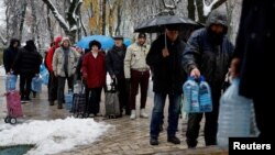 Kyiv residents stand in line to fill up bottles with fresh drinking water after critical civil infrastructure was hit by Russian missile attacks on the capital on November 24.