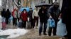  Local residents in Kyiv stand in line to fill up bottles with fresh drinking water. 