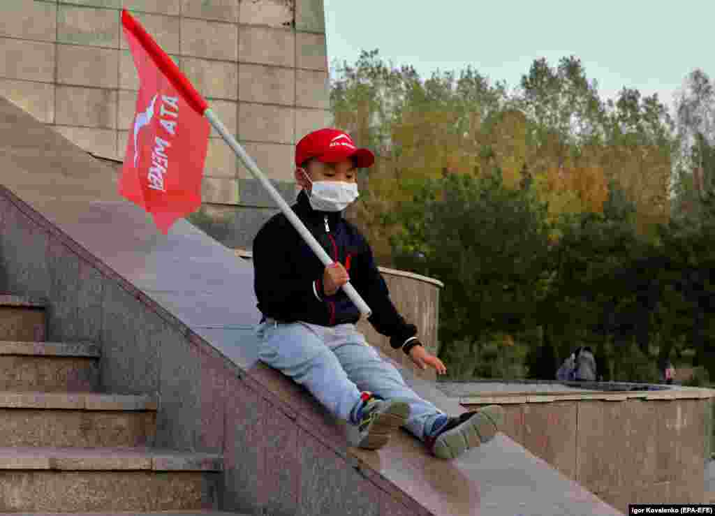 A little Kyrgyz boy holds the flag of the Ata-Meken party in Bishkek. (epa-EFE/Igor Kovalenko)