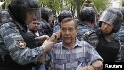 Riot police detain human rights activist Lev Ponomaryov during an unsanctioned protest in Moscow on May 7.