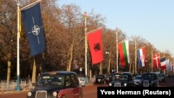 Londonska taxi vozila prolaze pored zastava zemalja članica NATO
