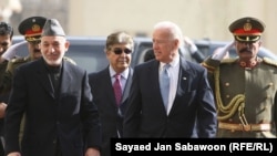 U.S. Vice President Joe Biden (center) and Afghan President Hamid Karzai (left) inspect an honor guard during their meeting in Kabul.