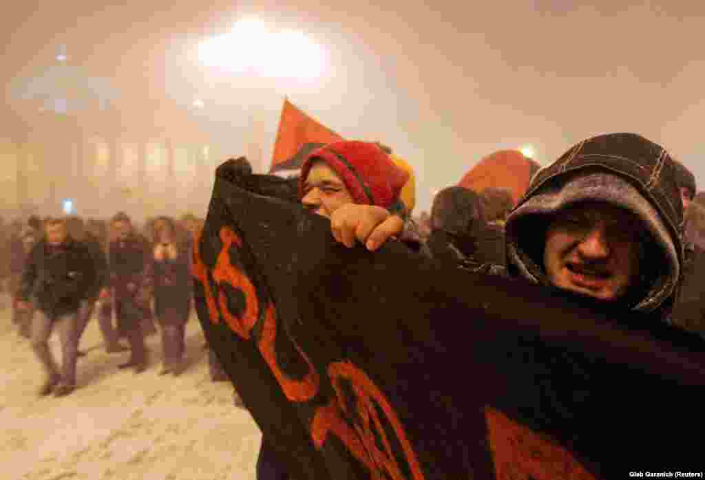 Antigovernment protesters push through a driving blizzard in Minsk.