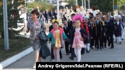 A teacher in Tatarstan leads children into the first day of school in September 2021. This year, the Russian republic faces a shortage of more than 2,000 teachers.