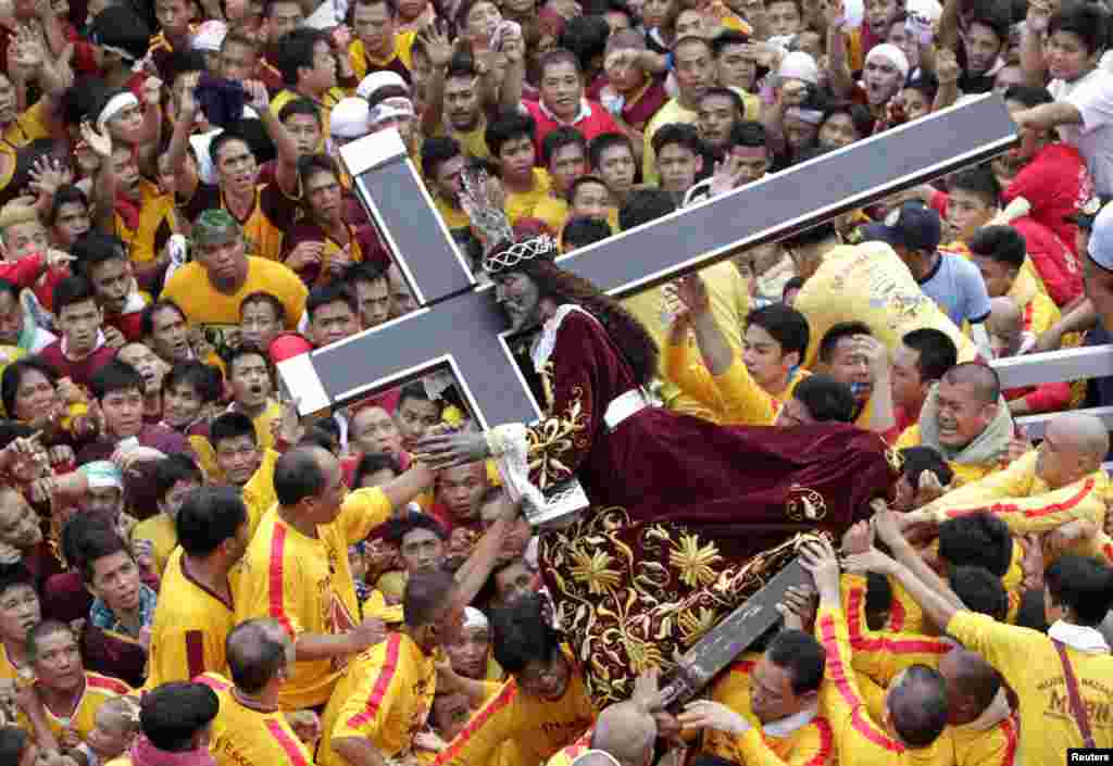 Devotees carry the statue of the Black Nazarene during the start of an annual procession in Manila. The Black Nazarene is a life-size wooden statue of Jesus Christ carved in Mexico and brought to the Philippines in the 17th century. It is believed to have healing powers in the predominantly Roman Catholic country. It is paraded through the narrow streets of Manila&#39;s old city from dawn to midnight. (Reuters/Erik De Castro)