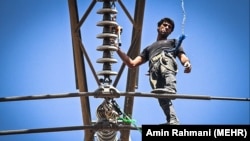 کارگری در قزوین در حال تعمیر یک دکل برق است