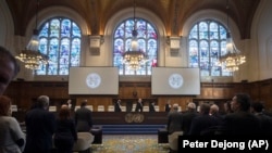 NETHERLANDS -- The delegations of the U.S., front left, and the Islamic Republic of Iran, front right, rise as judges, rear, enter the International Court of Justice, or World Court, in The Hague, October 3, 2018