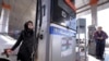 An Iranian woman fuels her car at a gas station in Tehran, January 25, 2016