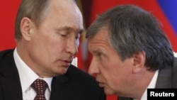 Ivan Sechin's father, Igor (right), is a longtime confidant of Russian President Vladimir Putin