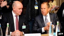 Switzerland -- Russian Foreign Minister Sergei Lavrov speaks to Vice Foreign Minister Grigory Karasin (L) before a meeting between representatives from Ukraine, the EU, and Russia in Geneva, April 17, 2014