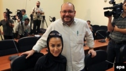 Iranian-American Washington Post correspondent Jason Rezaian (standing) and his Iranian wife Yeganeh Salehi pose while covering a press conference at Iran's Foreign Ministry in Tehran in September 2013.