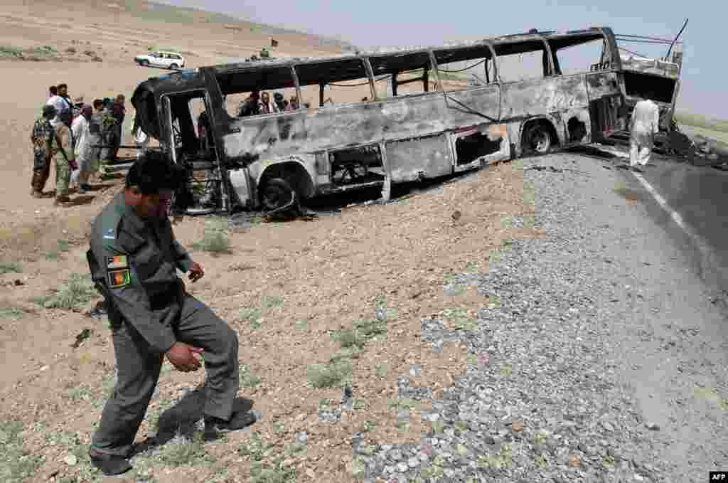 Afghan traffic police inspect the site where a passenger bus collided with a fuel tanker in Kandahar Province. At least 45 people were killed. (AFP/Noor Mohammad)