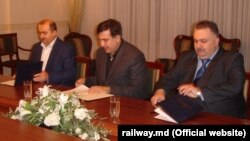 Генеральный директор Железной дороги Молдовы Юрий Топалэ (слева) подписывает соглашение о сотрудничестве со своим украинским коллегой Александром Завгородним и губернатором Одесской области Михаилом Саакашвили; октябрь 2015 года.