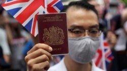 Улуу Британиянын Гонконгдогу консулдугунун алдына чогулган митингчилердин бири британ паспортун көтөрүп турат, 1-сентябрь 2019-жыл.