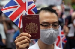 Житель Гонконга с "настоящим", а не "заморским" паспортом Великобритании протестует перед зданием британского консульства. Июль 2020 года