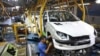 In this Oct. 11, 2014 file photo an Iranian worker assembles a Peugeot 206 at the state-run Iran-Khodro automobile manufacturing plant near Tehran, Iran.