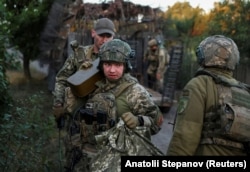 Ukrainian soldiers unload supplies from a military vehicle as they arrive for a combat mission in the Donetsk region on September 9.
