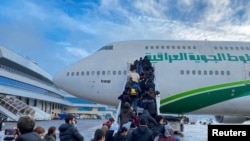 Iraki bevándorlók felszállása az első evakuációs járatra a minszki repülőtéren 2021. november 18-án