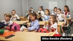 Першокласники у свій перший день навчального року в шкільному укритті під час удару російського безпілотника. Один із навчальних закладів у Києві, 1 вересня 2026 року 