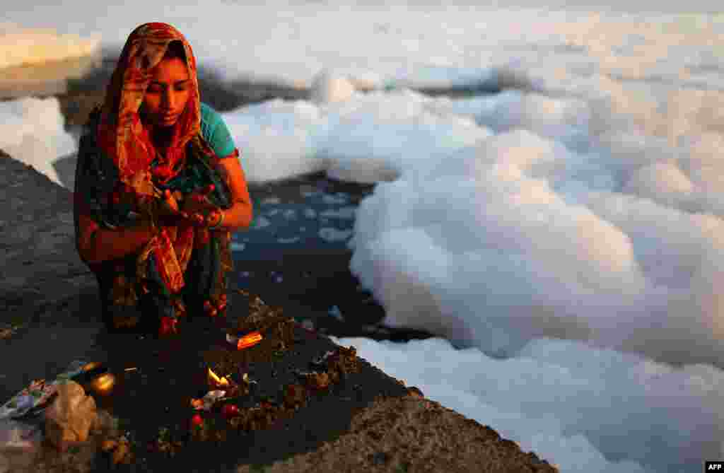 An Indian Hindu devotee prays near the polluted Yamuna River in New Delhi. India&#39;s Supreme Court said that all measurements of water quality indicate that it is highly polluted and urged authorities to tackle the problem. More than 2,400 million liters of untreated sewage flows into the Yamuna every day. (AFP/Andrew Caballero-Reynolds)