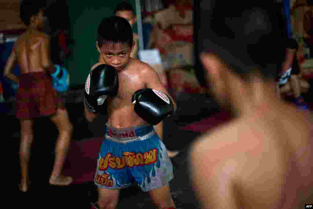 Young Muay Thai boxer resting and getting coached between rounds.