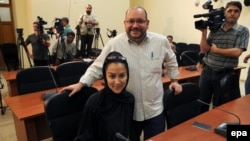 Iranian-American correspondent Jason Rezaian and his Iranian wife, Yeganeh Salehi, pose while covering a press conference at Iran's Foreign Ministry in Tehran in September 2013.