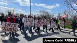 Demonstranti u Novom Sadu protestuju zbog hapšenja aktivista čija imena nose na čelu kolone, 12. aprila 2025. godine. 