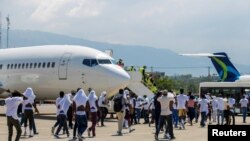 Deportovani migranti pokušavaju se ponovo ukrcati u avion na aerodromu u Port-au-Princeu, Haiti (21. septembar 2021.)