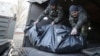 Ukrainian soldiers unload the bodies of their comrades killed in Debaltseve at a checkpoint near Horlivka on February 24.