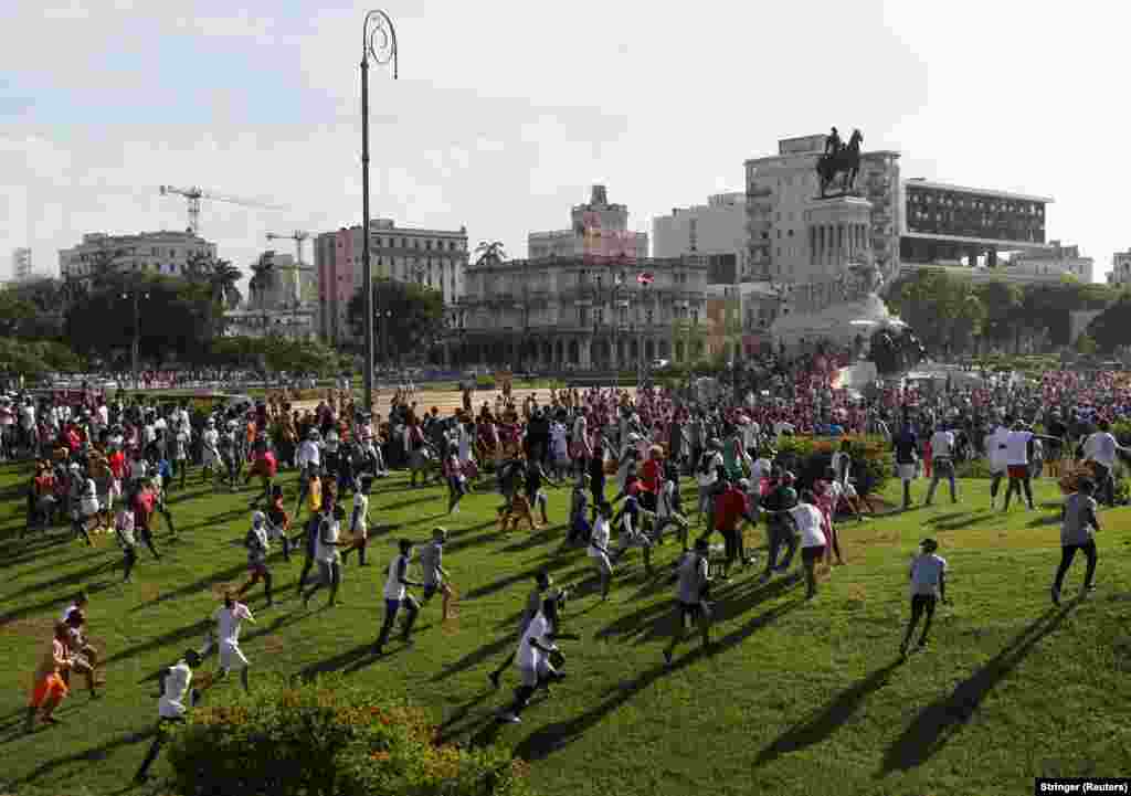 Njerëzit ikin gjatë protestave kundër dhe në mbështetje të qeverisë, të zhvilluara teksa koronavirusi po vazhdon të përhapet shumë, në Havanë.