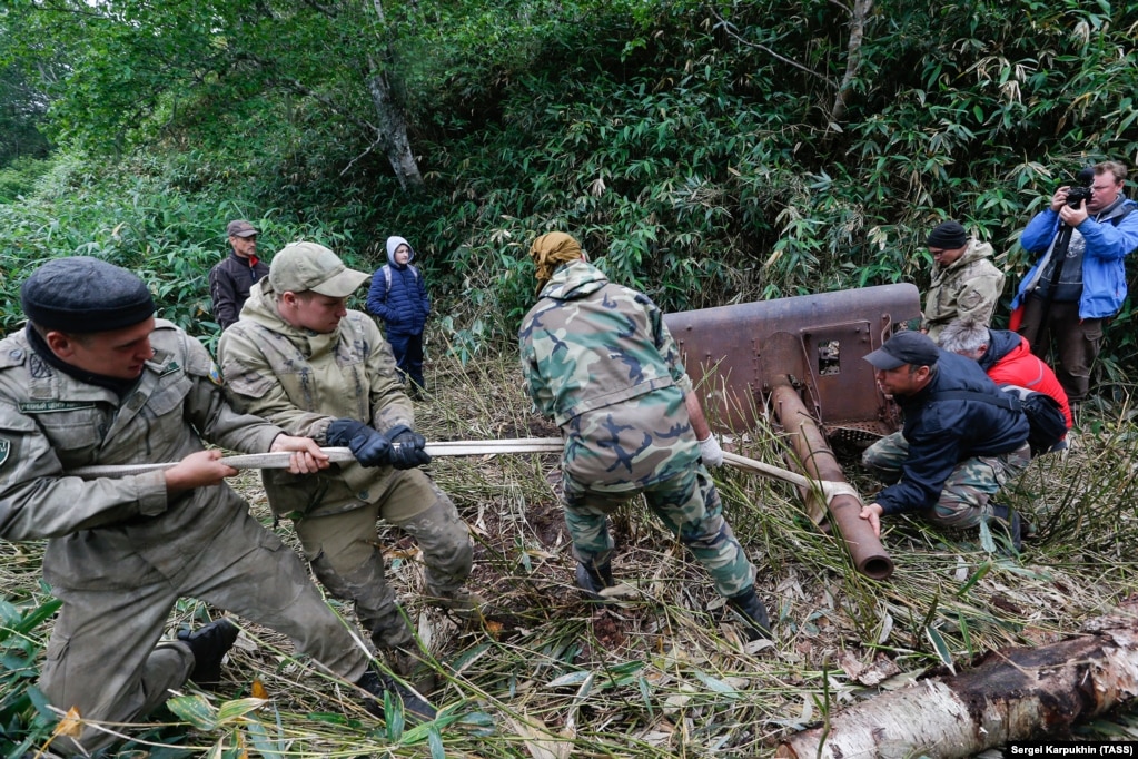 Members of the expedition, which was organized by the Russian Geographical Society and the Russian Defense Ministry, haul an artillery piece from the jungle of Iturup. The photo was released by the TASS news agency on August 19.