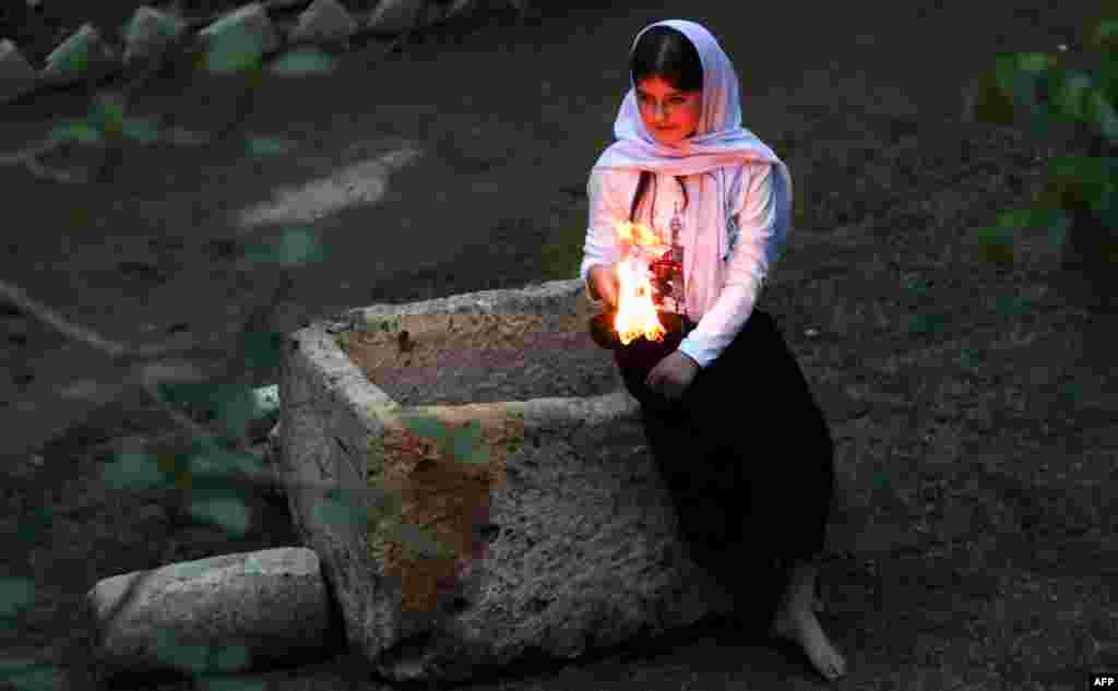 Iraqi Yazidis light candles and paraffin torches outside a temple northwest of Baghdad during a ceremony to celebrate the Yazidi New Year on April 18. (AFP/Safin Hamed)