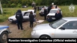 Russian investigators examine the site of a fracas that took place in the village of Chemodanovka on June 13